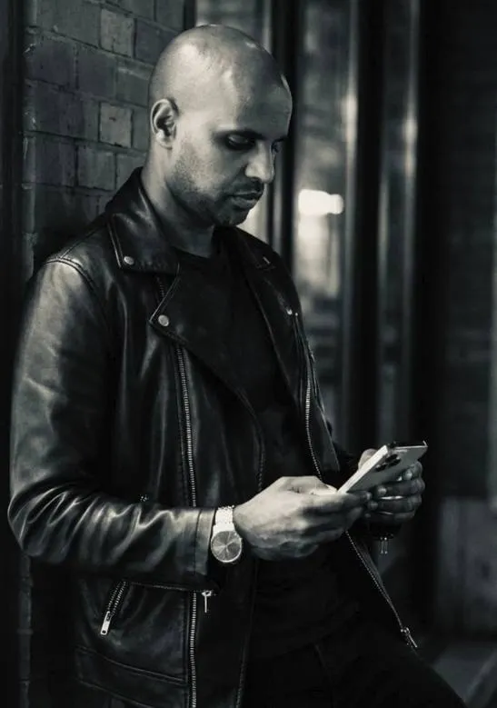 Daniel schaut auf ein Smartphone.